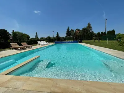 a large swimming pool with blue water in a yard at Vila Tea Fruska Gora in Čortanovci