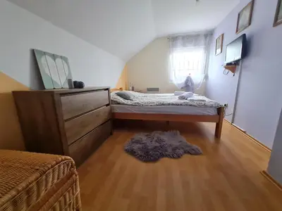 a bedroom with a bed and a dresser and a window at Vila Tea Fruska Gora in Čortanovci