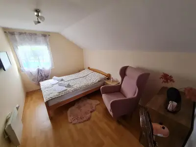 a small bedroom with a bed and a chair at Vila Tea Fruska Gora in Čortanovci