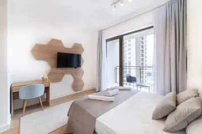 a bedroom with a bed and a desk and a television at BW VERDE DREAM in Sajmište
