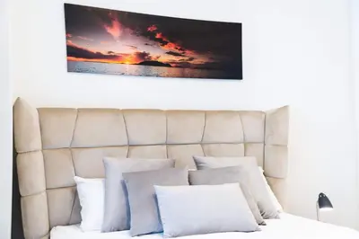 a bed with white pillows and a painting on the wall at BW VERDE DREAM in Sajmište