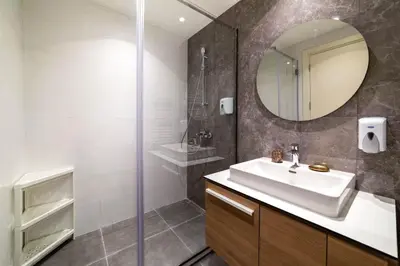 a bathroom with a sink and a shower with a mirror at BW VERDE DREAM in Sajmište