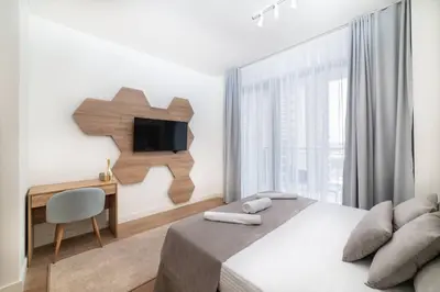 a bedroom with a bed and a desk and a television at BW VERDE DREAM in Sajmište