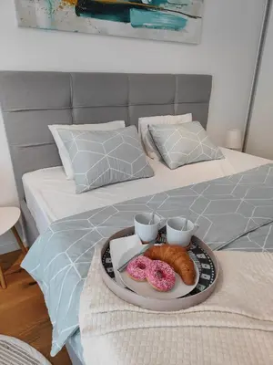 a tray with two donuts and two cups on a bed at Elixir in Belgrade
