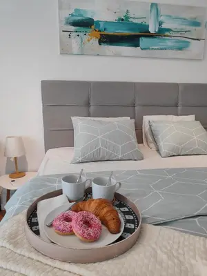 a tray with three donuts and two cups on a bed at Elixir in Belgrade