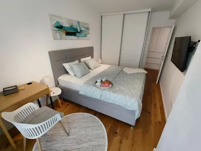 a small bedroom with a bed and a table at Elixir in Belgrade