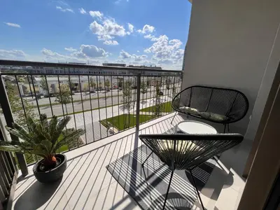 a balcony with a table and a chair on a balcony at ZIGZAG Belgrade Waterfront Aqua in Belgrade