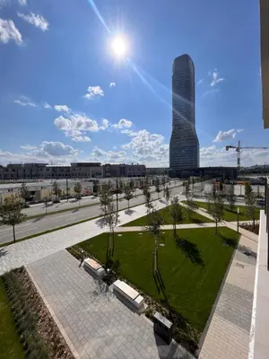 a park with a tall building in the background at ZIGZAG Belgrade Waterfront Aqua in Belgrade