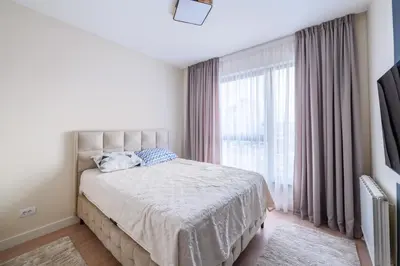 a bedroom with a bed and a large window at ZIGZAG Belgrade Waterfront Aqua in Belgrade