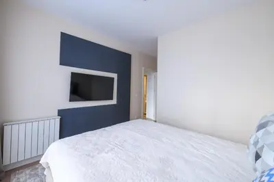 a bedroom with a white bed and a blue wall at ZIGZAG Belgrade Waterfront Aqua in Belgrade