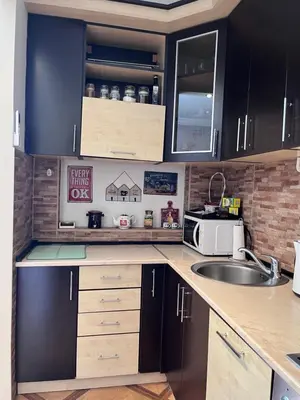 a kitchen with black cabinets and a sink at Apartman Sasha 1 - Ask for free parking in Sajmište