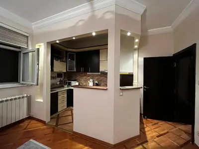 a kitchen with black and white cabinets and a counter at Apartman Sasha 1 - Ask for free parking in Sajmište