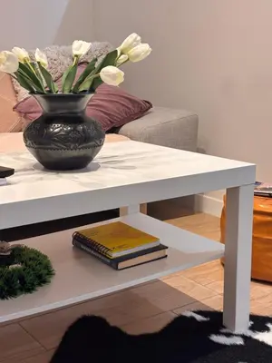 a white coffee table with a vase on top of it at HUGO OLD TOWN in Belgrade