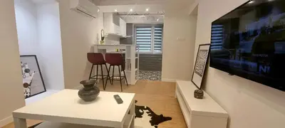 a living room with a television and a table and chairs at HUGO OLD TOWN in Belgrade