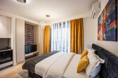 a bedroom with a large bed and a television at inJoy in Belgrade