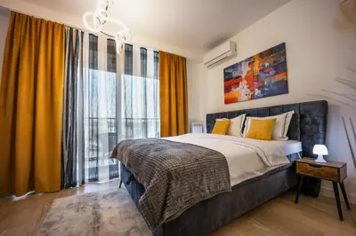 a bedroom with a bed and a large window at inJoy in Belgrade
