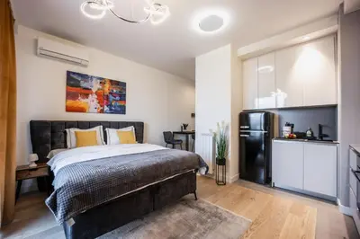 a bedroom with a large bed and a refrigerator at inJoy in Belgrade