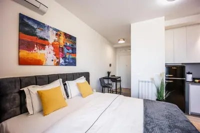 a bedroom with a large bed with yellow pillows at inJoy in Belgrade