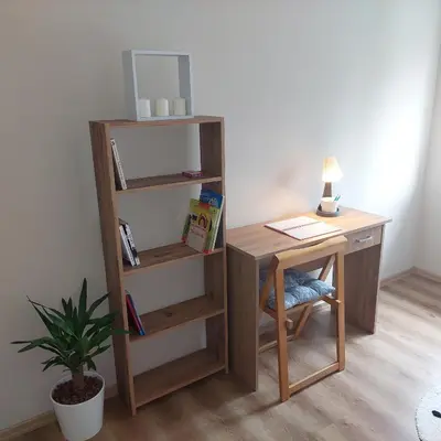 a desk with a chair next to a table with a lamp at Charna apartment Beograd Železnik in Železnik