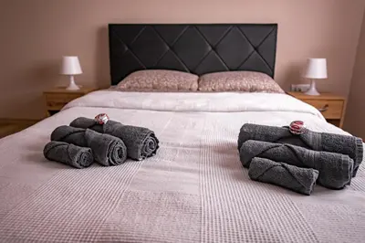 a bed with a bunch of towels on it at Charna apartment Beograd Železnik in Železnik