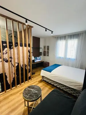 a bedroom with a large bed and a couch at Parliament Studio Appartment in Belgrade