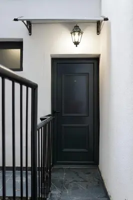 a black door with a light on the side of a building at Parliament Studio Appartment in Belgrade