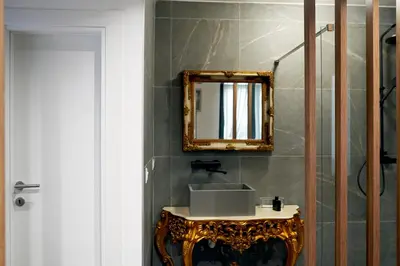 a bathroom with a sink and a mirror on a wall at Parliament Studio Appartment in Belgrade