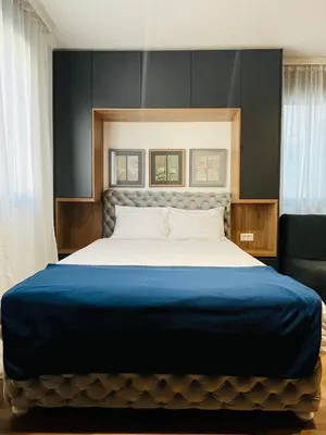 a bedroom with a large bed with a blue blanket at Parliament Studio Appartment in Belgrade