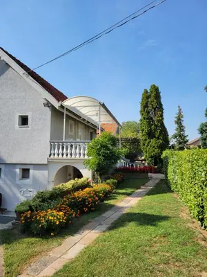 a house with a balcony and flowers in a yard at Green Garden Apartments in Surčin