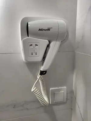 a phone hanging on a wall in a bathroom at HARMONY Suites (Savska ulica) in Sajmište