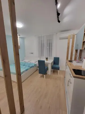 a bedroom with a bed and a table and chairs at HARMONY Suites (Savska ulica) in Sajmište