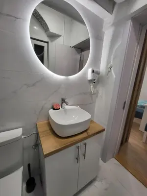 a bathroom with a sink and a mirror at HARMONY Suites (Savska ulica) in Sajmište