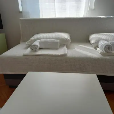 a bedroom with two beds with towels and a window at RIVIJERA LAKES Ada Studio in Belgrade