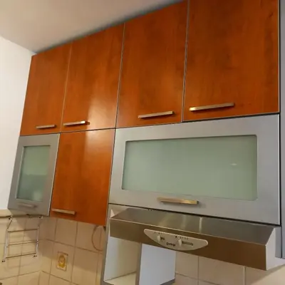a kitchen with wooden cabinets and a microwave at RIVIJERA LAKES Ada Studio in Belgrade