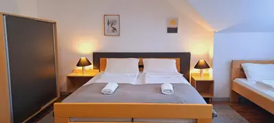 a bedroom with a bed with two lamps and two beds at Magellan Apartments in Belgrade