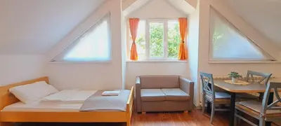 a room with a bed and a table and windows at Magellan Apartments in Belgrade