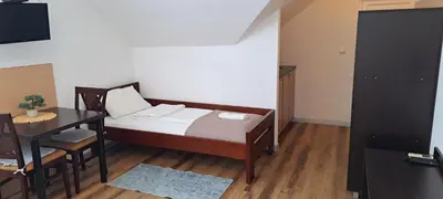 a small bedroom with a bed and a table at Magellan Apartments in Belgrade