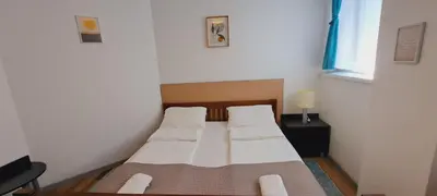 a small bedroom with two beds and a window at Magellan Apartments in Belgrade