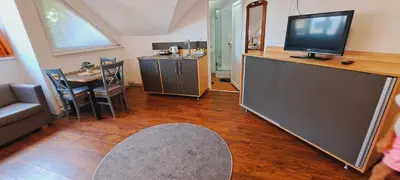 a living room with a television and a table with chairs at Magellan Apartments in Belgrade