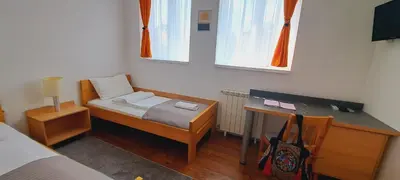 a small bedroom with a bed and a desk at Magellan Apartments in Belgrade
