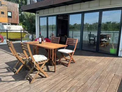 a wooden table and chairs sitting on a deck at Floating Zen House in Belgrade