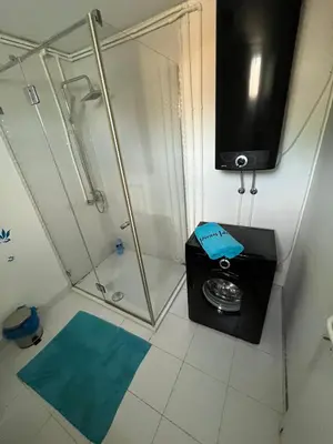 a bathroom with a shower and a television on the wall at Floating Zen House in Belgrade