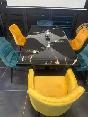 a table and chairs with yellow chairs around it at Bella apartman in Mladenovac