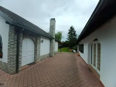 a house with two garage doors and a brick driveway at Apartman u potkrovlju in Sremski Karlovci