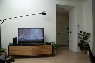 a living room with a flat screen tv on a wooden dresser at Belgrade Waterfront Sunshine apartment in Belgrade