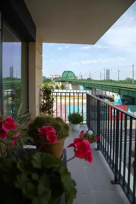 a balcony with flowers and a view of a bridge at Belgrade Waterfront Sunshine apartment in Belgrade