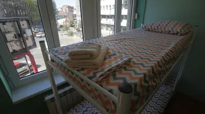 a small bed in a room with a window at Stella Di Notte VIP in Belgrade