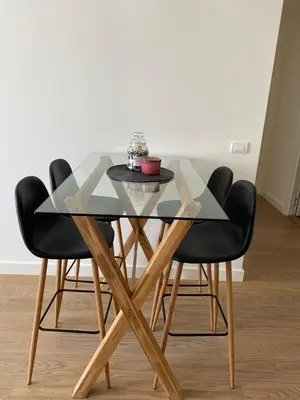 a glass table with four black chairs around it at Verde 18 in Sajmište