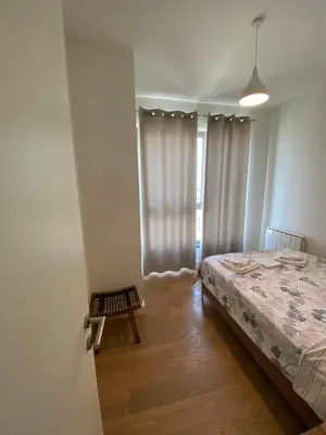 a bedroom with a bed and a window with curtains at Verde 18 in Sajmište