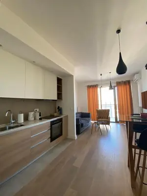 a kitchen and living room with a table and chairs at Verde 18 in Sajmište